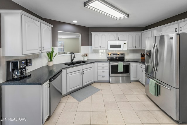 kitchen with appliances with stainless steel finishes, sink, and white cabinets