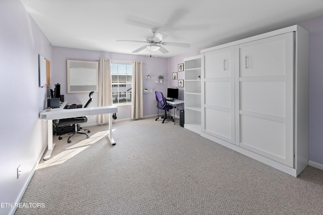 carpeted office space with ceiling fan