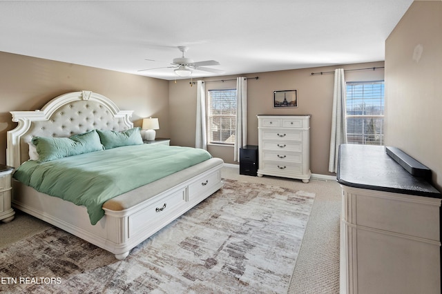 bedroom with ceiling fan, light colored carpet, and multiple windows