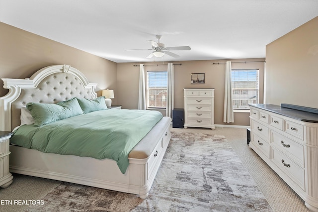 bedroom with multiple windows, light carpet, and ceiling fan