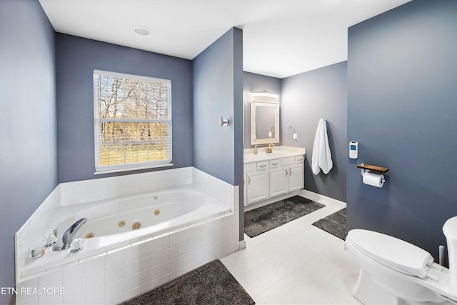 bathroom featuring vanity, a relaxing tiled tub, and toilet