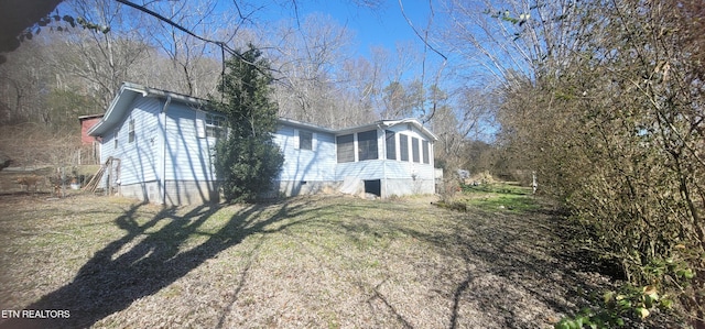 view of home's exterior featuring a yard and a sunroom