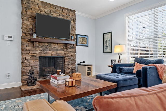 living room with crown molding, a stone fireplace, and dark wood-type flooring