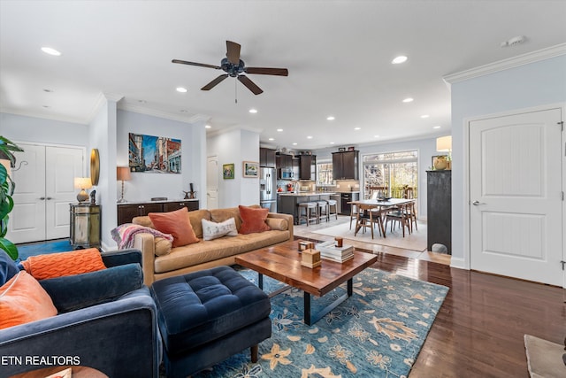 living room featuring crown molding, dark wood-type flooring, and ceiling fan