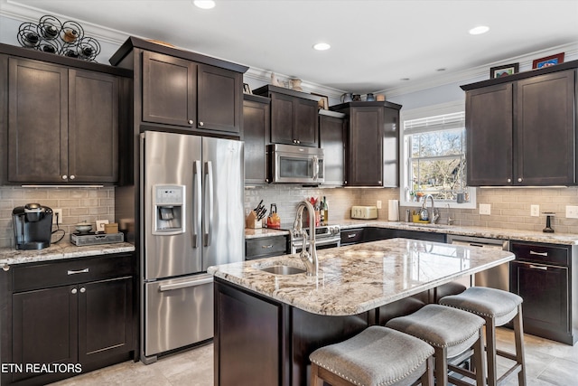 kitchen with dark brown cabinetry, a kitchen bar, a center island, and appliances with stainless steel finishes