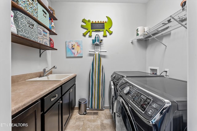 laundry room featuring sink, cabinets, and independent washer and dryer