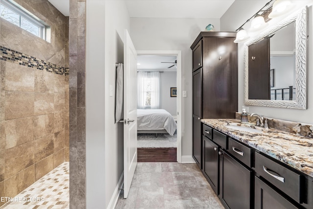 bathroom with a tile shower and vanity