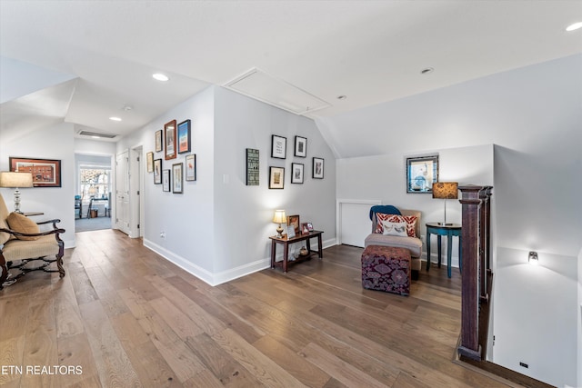 living area featuring lofted ceiling and hardwood / wood-style floors