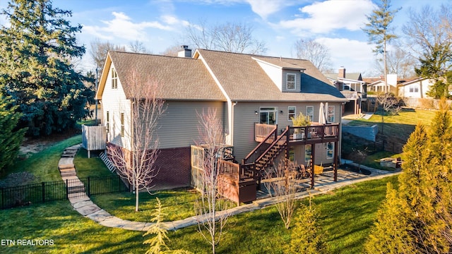 rear view of property with a yard and a deck