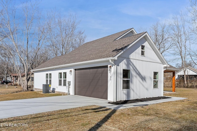 exterior space featuring a garage, a lawn, and central air condition unit