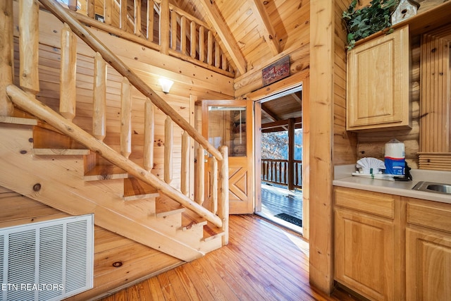 stairs featuring hardwood / wood-style floors, vaulted ceiling with beams, and wood ceiling