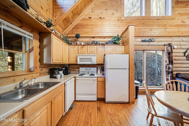 kitchen featuring sink, white appliances, high vaulted ceiling, and rustic walls