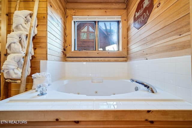 bathroom with tiled bath and wooden walls