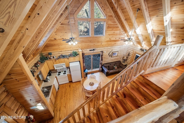 living room featuring hardwood / wood-style floors, log walls, wooden ceiling, high vaulted ceiling, and beam ceiling