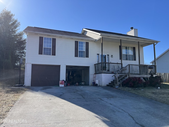 split foyer home with a garage and covered porch