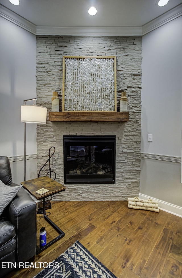 interior space with hardwood / wood-style flooring, ornamental molding, and a fireplace