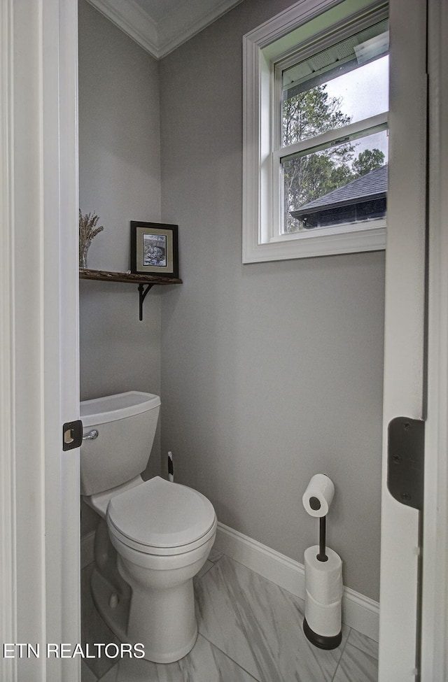 bathroom with crown molding and toilet