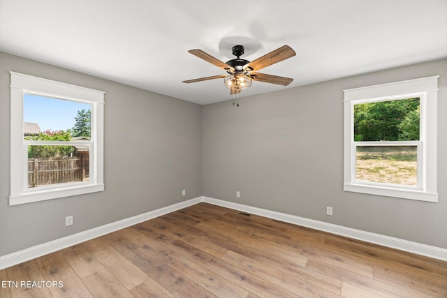 spare room with plenty of natural light, light hardwood / wood-style floors, and ceiling fan