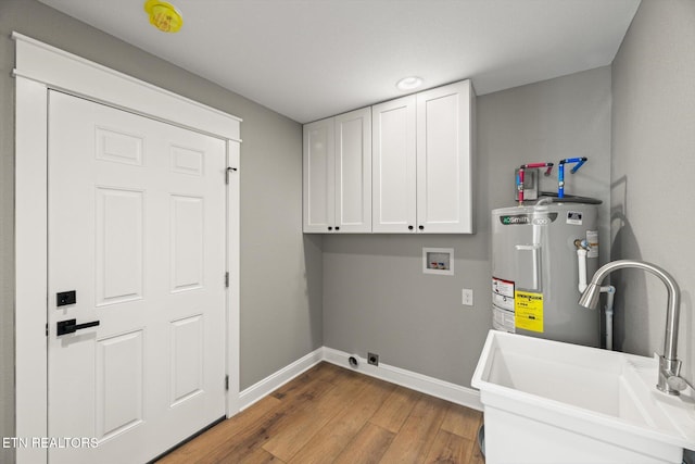 washroom featuring sink, hardwood / wood-style floors, cabinets, electric water heater, and washer hookup