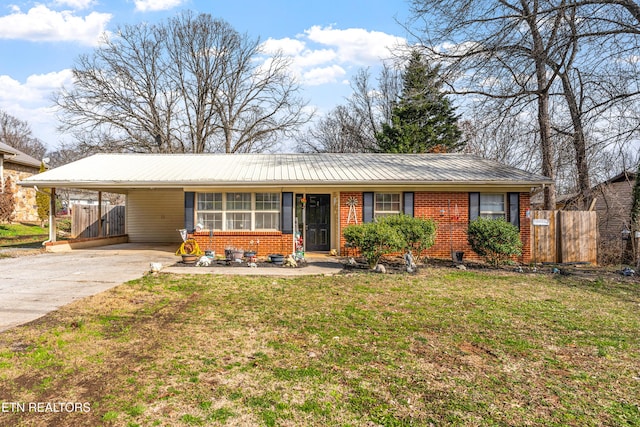 ranch-style house with brick siding, an attached carport, a front yard, and fence