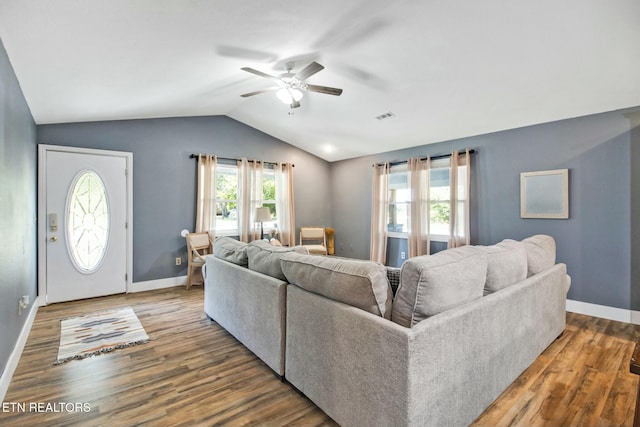 living room with ceiling fan, vaulted ceiling, and wood-type flooring