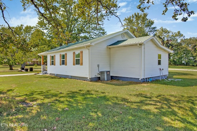 view of side of property featuring a yard and central air condition unit