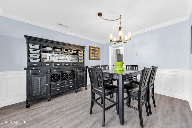 dining room featuring crown molding, a chandelier, and hardwood / wood-style floors