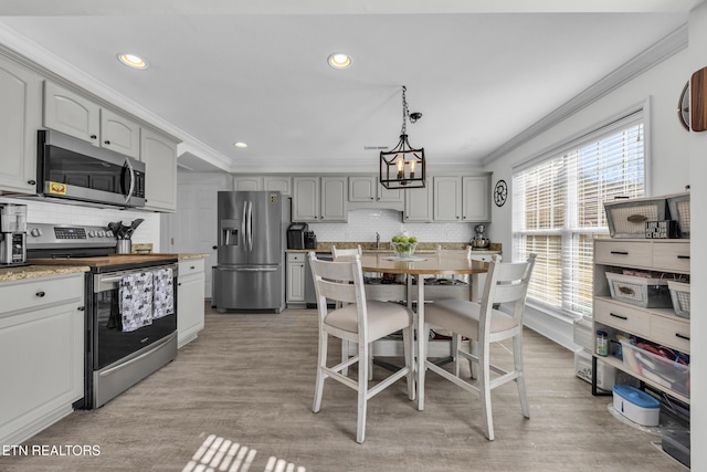 kitchen with sink, gray cabinets, appliances with stainless steel finishes, ornamental molding, and decorative light fixtures