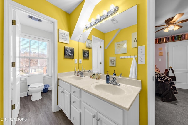 bathroom with hardwood / wood-style flooring, vanity, ceiling fan, and toilet