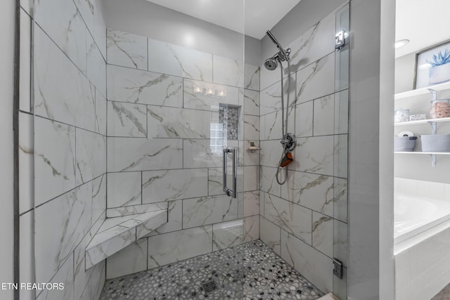 bathroom featuring shower with separate bathtub