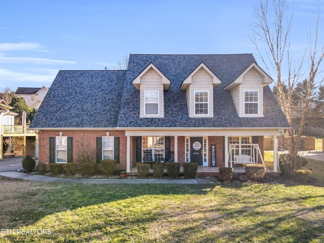 cape cod home with covered porch and a front lawn