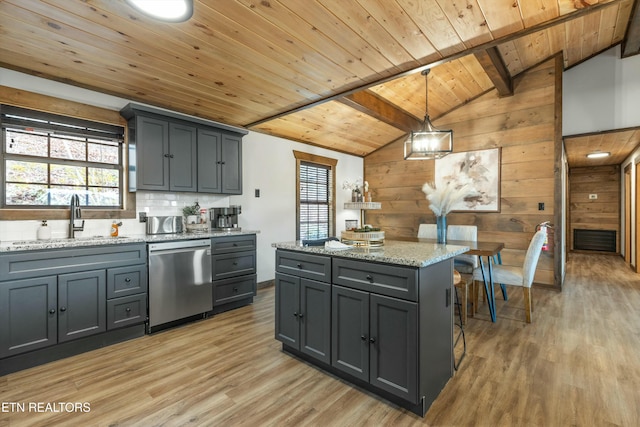 kitchen featuring sink, gray cabinets, a kitchen island, decorative light fixtures, and stainless steel dishwasher