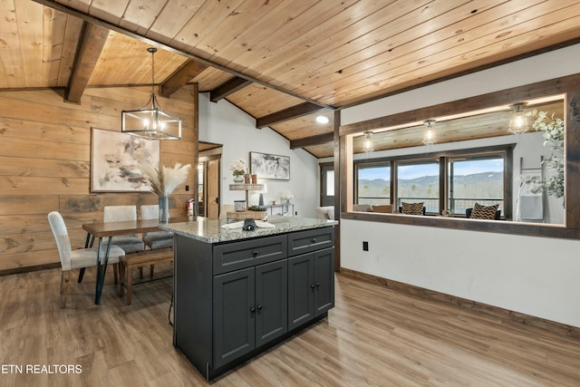 kitchen featuring vaulted ceiling with beams, wood ceiling, hanging light fixtures, a kitchen island, and light stone countertops