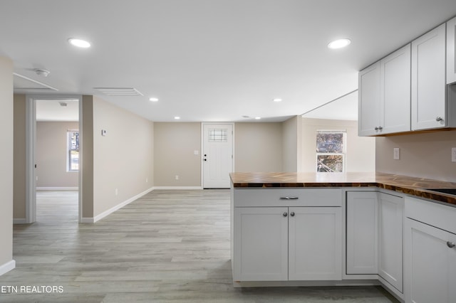 kitchen featuring white cabinetry, light hardwood / wood-style floors, and kitchen peninsula