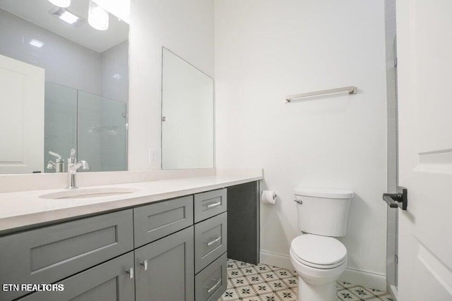 full bath featuring tile patterned floors, vanity, a shower with door, baseboards, and toilet