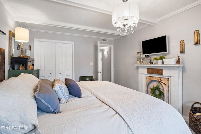 bedroom with crown molding, beam ceiling, a notable chandelier, a textured ceiling, and a closet