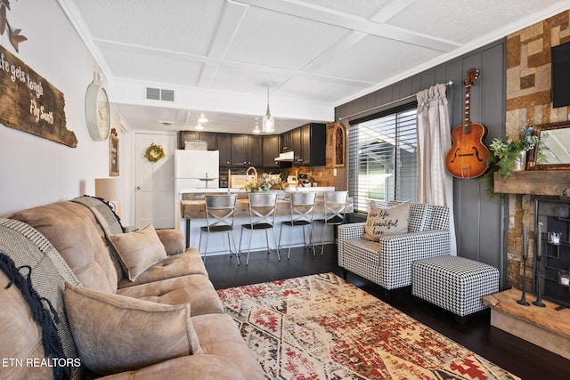 living room featuring beamed ceiling, wood-type flooring, and coffered ceiling