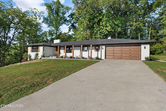 view of front of property with a garage and a front lawn