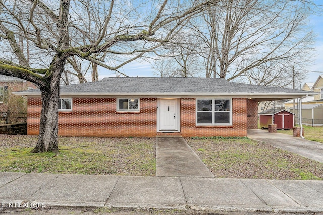 ranch-style home featuring a carport and a storage unit