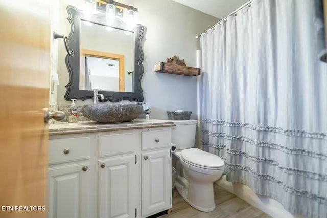 full bathroom featuring vanity, shower / bath combo, and toilet