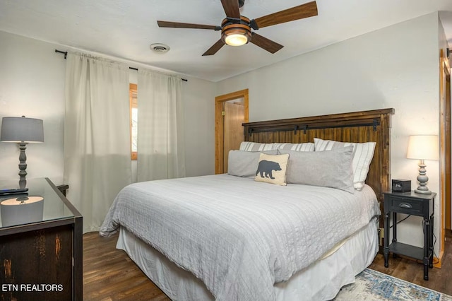 bedroom with dark hardwood / wood-style floors and ceiling fan