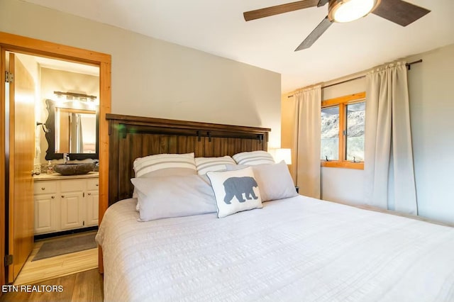 bedroom featuring ensuite bath, ceiling fan, and light wood-type flooring