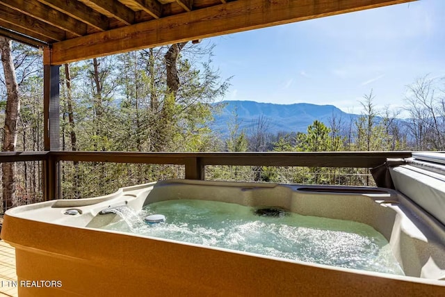 deck featuring a mountain view and a hot tub