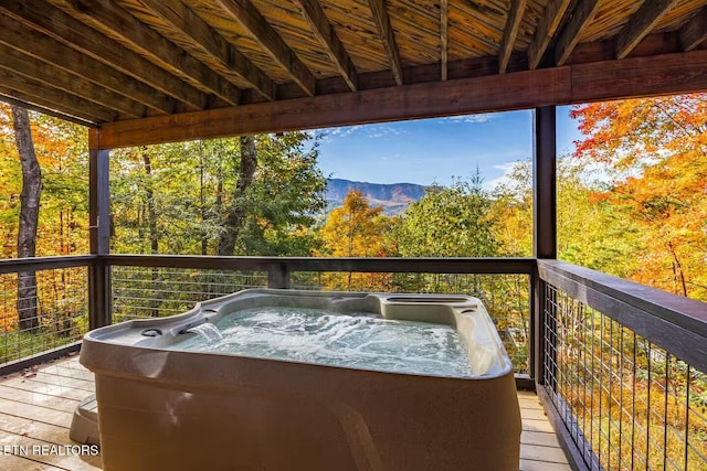 deck with a mountain view and a hot tub