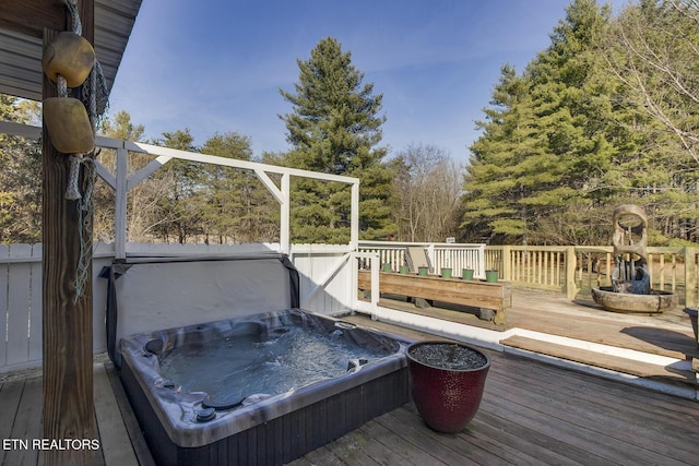 deck featuring a covered hot tub