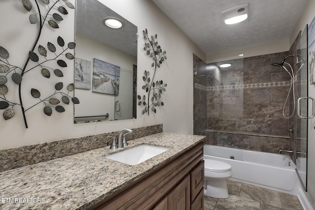 full bathroom with vanity, tiled shower / bath, toilet, and a textured ceiling