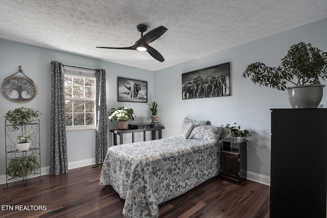 bedroom with ceiling fan, dark hardwood / wood-style flooring, and a textured ceiling