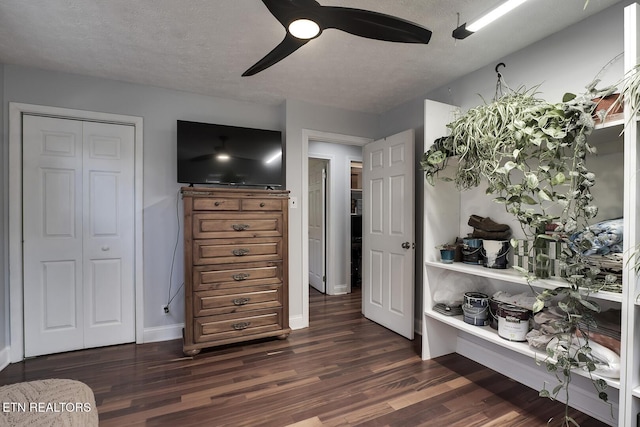 bedroom with ceiling fan, dark hardwood / wood-style floors, a closet, and a textured ceiling