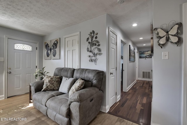 living room with hardwood / wood-style flooring and a textured ceiling