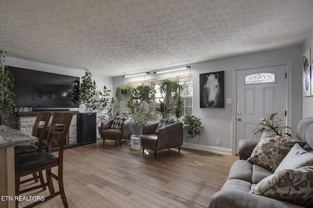 living room with a textured ceiling and light wood-type flooring